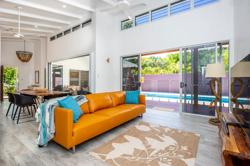 42 HL — living room with orange sofa, raked ceiling and pool outlook