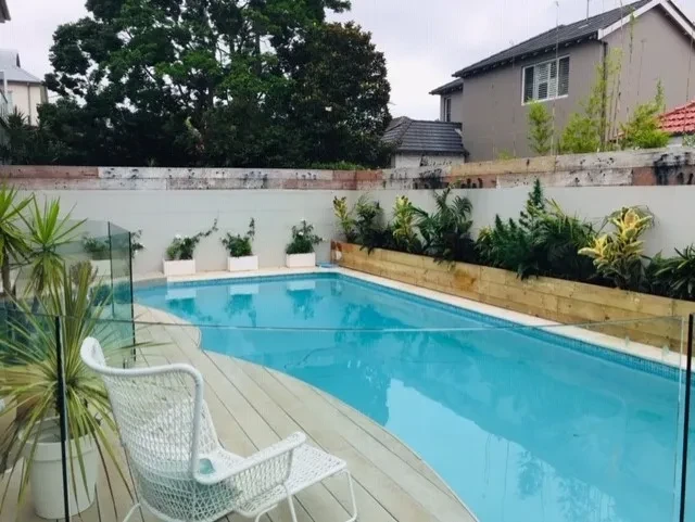 Beach House — pool with glass fencing, timber deck and tropical garden planting