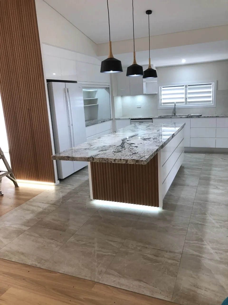 Myserton — kitchen with stone island, timber battens and pendant lights
