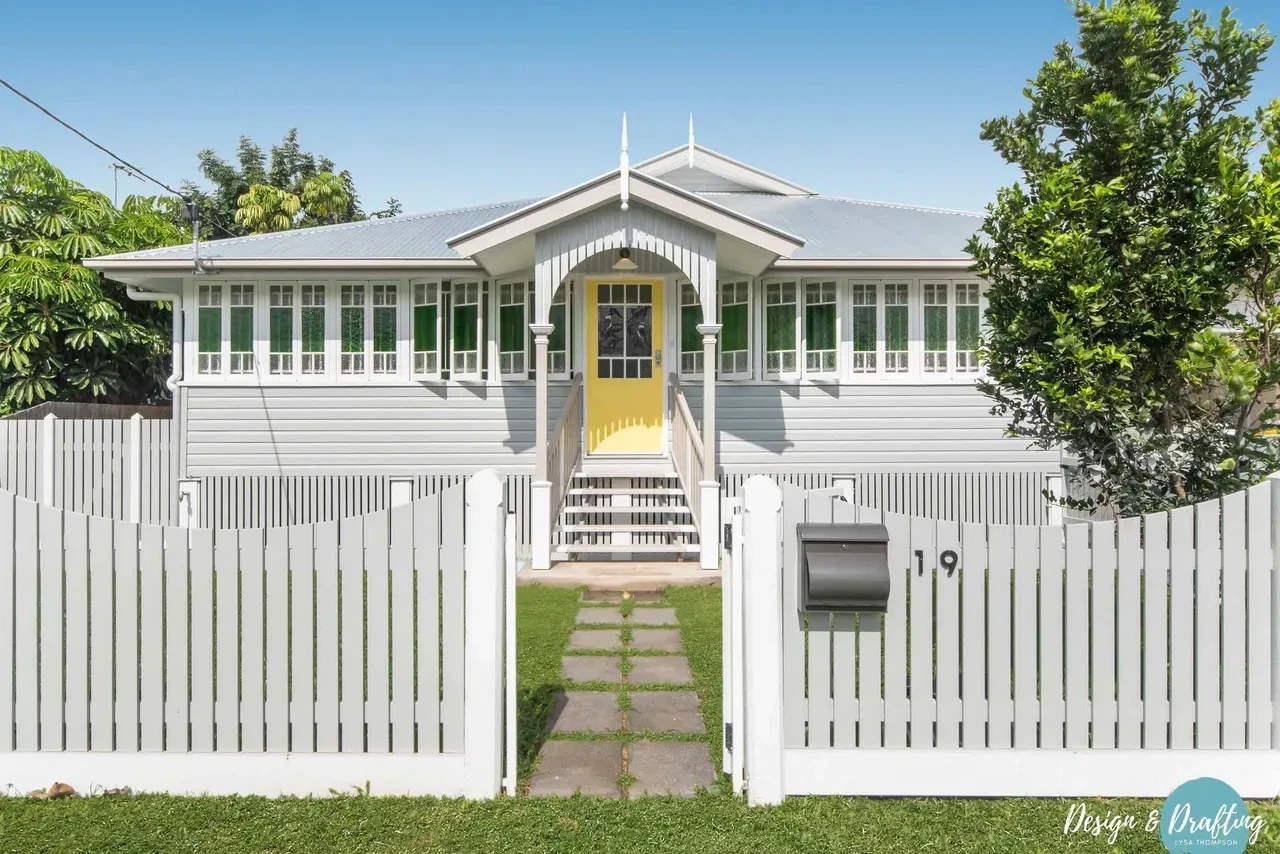 Myserton — Queenslander front facade with yellow door and picket fence