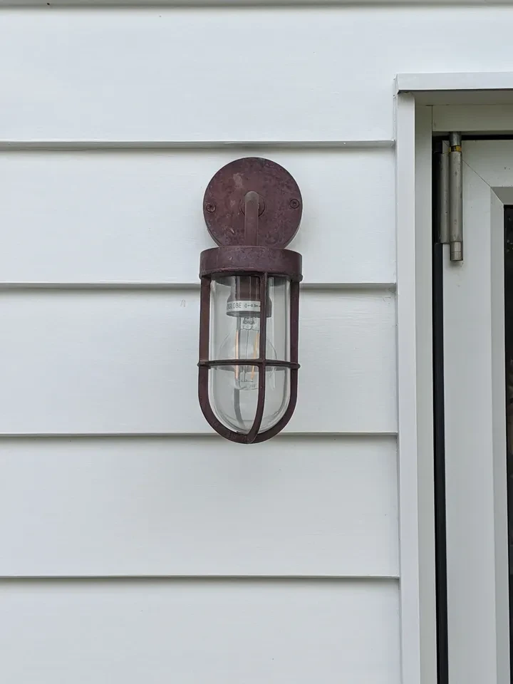 reef shack — vintage cage wall light on white cladding