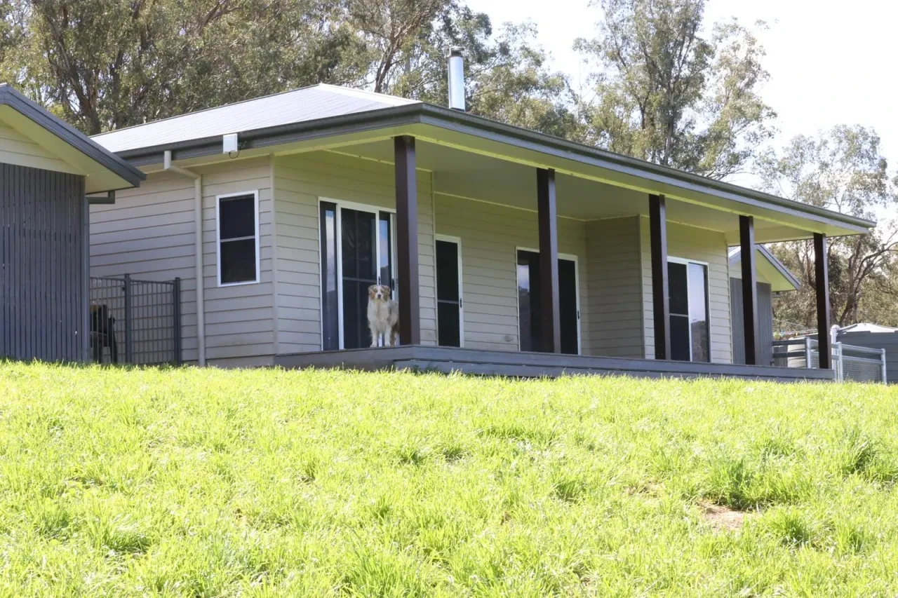 WIDDEN — completed homestead front elevation with verandah, dog on deck and lush green lawn
