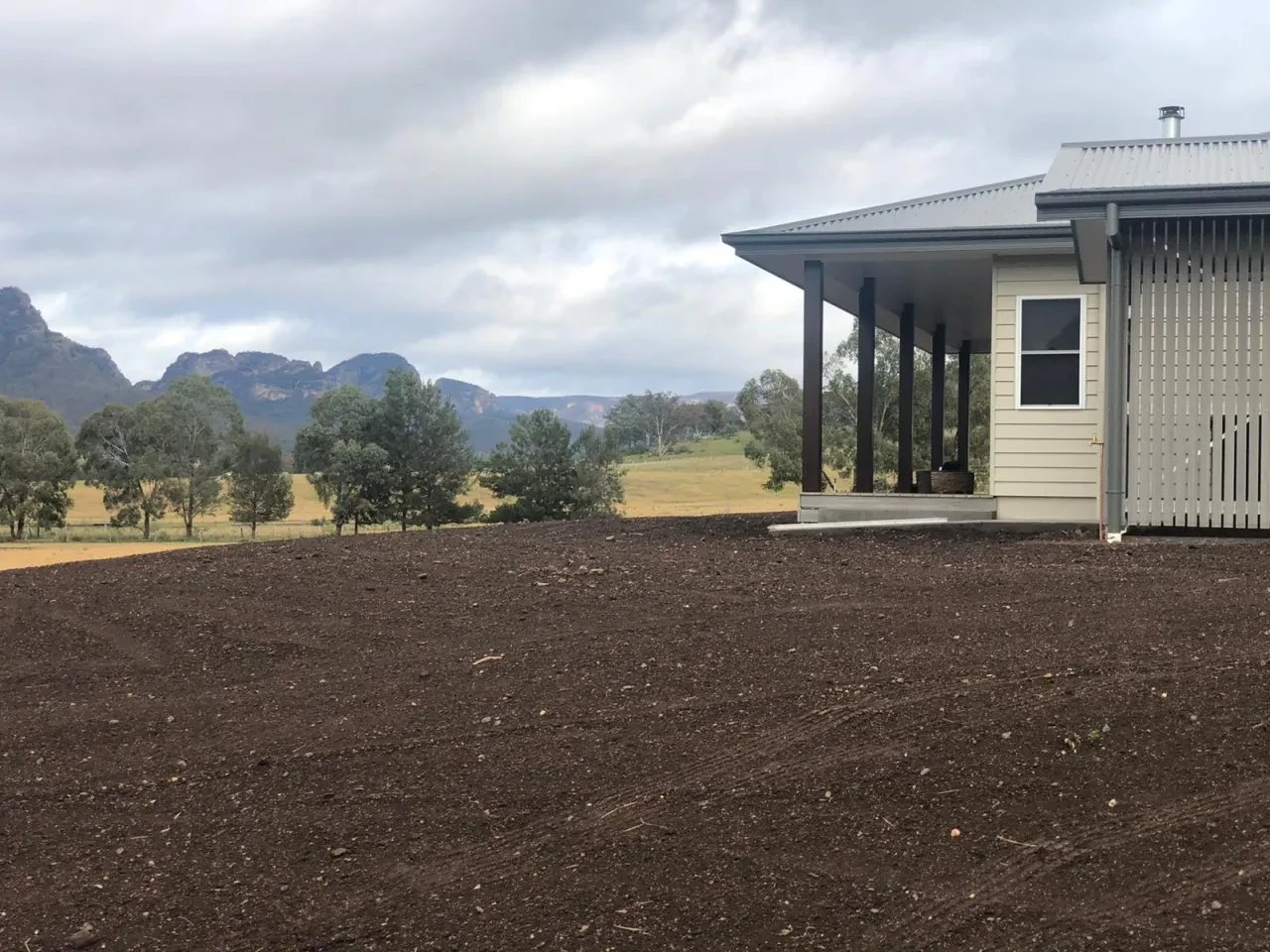 WIDDEN — side elevation of completed homestead with covered verandah and mountain valley views